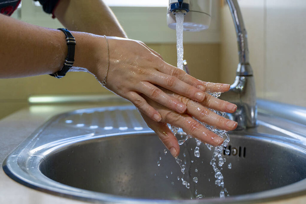 Lavarsi bene le mani. Concetto di igiene. Strofinando il dorso della mano con le dita intrecciate
. - Foto, immagini