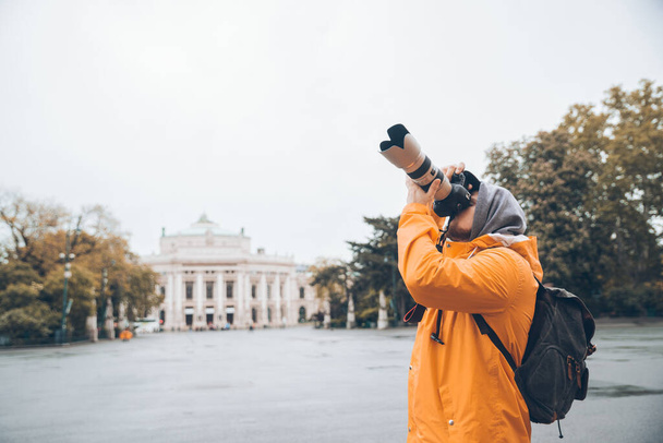 都市建築の写真を撮るプロのカメラと大きなレンズを持つ男コピースペース観光 - 写真・画像