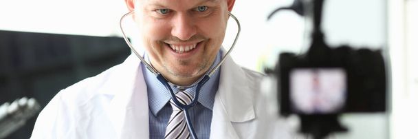 Smiling doctor shows to listen lungs stethoscope - Photo, Image