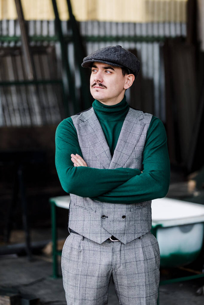 Well-dressed man wearing a grey retro suit, cap and green jersey - Foto, Imagen