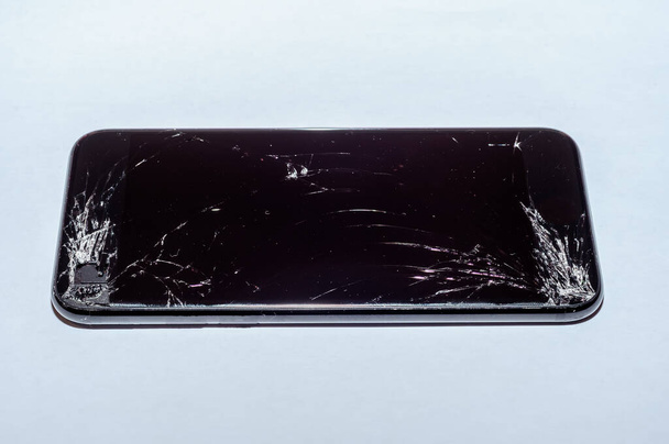 Widok na pęknięty ekran smartfona odizolowanego na białym tle. - Zdjęcie, obraz