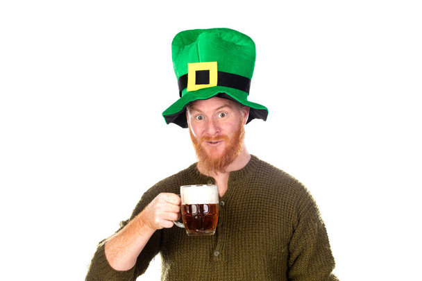 Rudy mężczyzna w wielkim zielonym kapeluszu pijący piwo na białym grzbiecie - Zdjęcie, obraz
