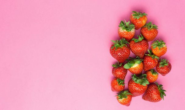 ピンクの背景にジューシーなイチゴを熟す。パターン、フレッシュベリーフラットレイ。創造的な最小限の食品コンセプト - 写真・画像