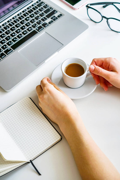 coffee mug, notebook, laptop and female hand on the table on a white background - Photo, image