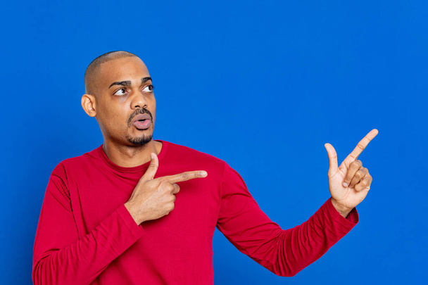 African guy with red jersey on a blue background - Fotó, kép