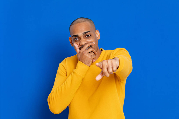 Chico africano con una camiseta amarilla sobre un fondo azul
 - Foto, Imagen