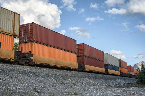 Tren de carga larga que pasa con carga de contenedores en el ferrocarril en el valle en Calgary, Canadá
 - Foto, Imagen