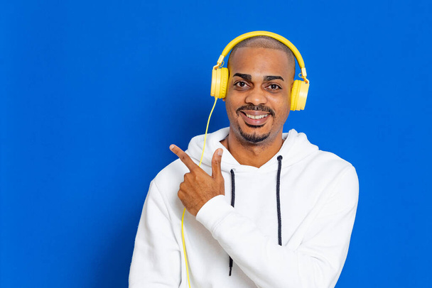 African guy wearing a white sweatshirt on a blue background - Photo, image
