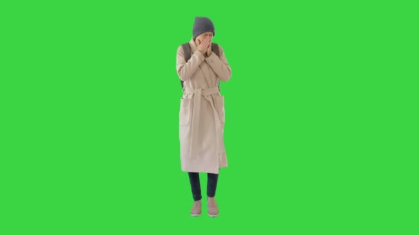 Nő egy kabátban séta és köhögés egy zöld képernyőn, Chroma Key. - Felvétel, videó
