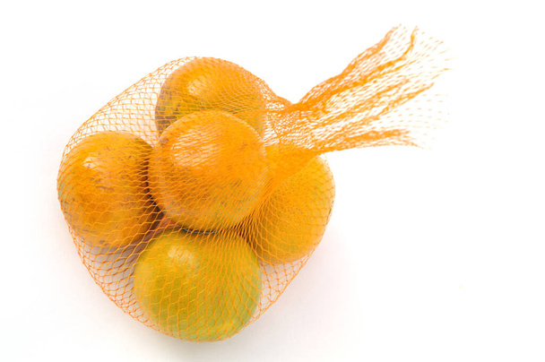 Horní pohled na zralé mandarinky oranžové v síťované tašce - Fotografie, Obrázek