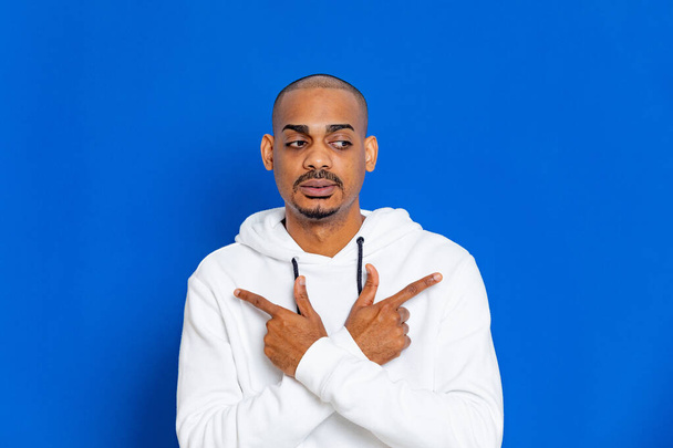 African guy wearing a white sweatshirt on a blue background - 写真・画像