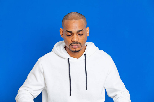 African guy wearing a white sweatshirt on a blue background - Photo, image