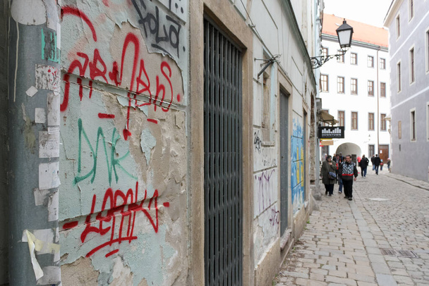 Bratislava, Slowakei - April 2011: Graffiti, alte Gebäude und Menschen in der Klariska-Straße. - Foto, Bild