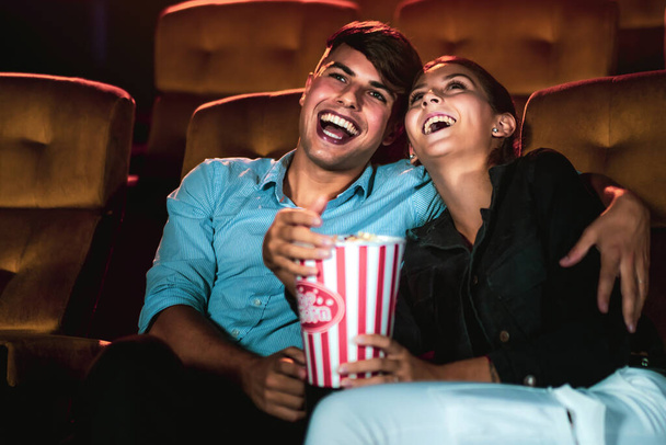 Мужчина и женщина смотрят кино в кинотеатре. Концепция группового отдыха и развлечений. - Фото, изображение
