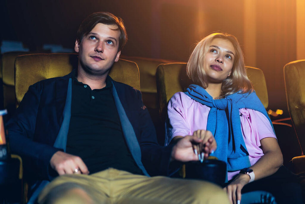 Kaukasischer Liebhaber genießt es, Film zu sehen und Popcorn zusammen im Kino zu essen - Foto, Bild