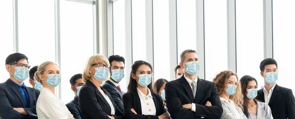 Pessoas de negócios confiantes com máscara facial protegem de Coronavirus ou COVID-19. Conceito de ajuda, apoio e colaboração para superar a epidemia de Coronavirus ou COVID-19 para reabrir os negócios
. - Foto, Imagem