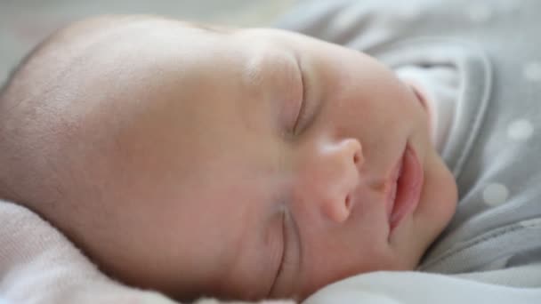 Közelkép egy gyönyörű újszülött gyerekről, aki az ágyban alszik. - Felvétel, videó