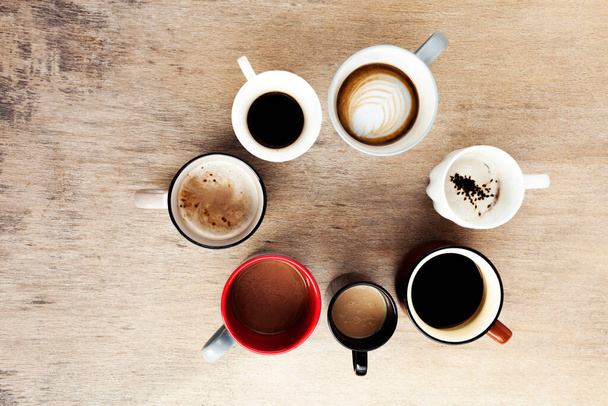 Багато чашок кави на дерев'яному столі, вид зверху
 - Фото, зображення