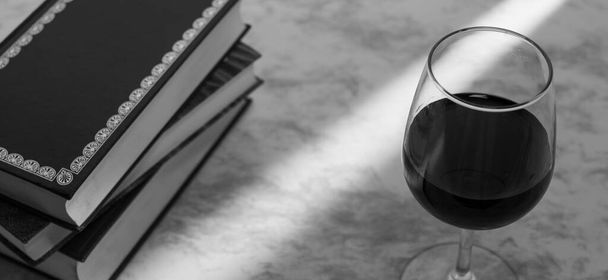 Copa de vino acompanada de unos libros y una camara fotografica con la luz de la venta entrando por un costado en blanco y negro - Foto, Bild