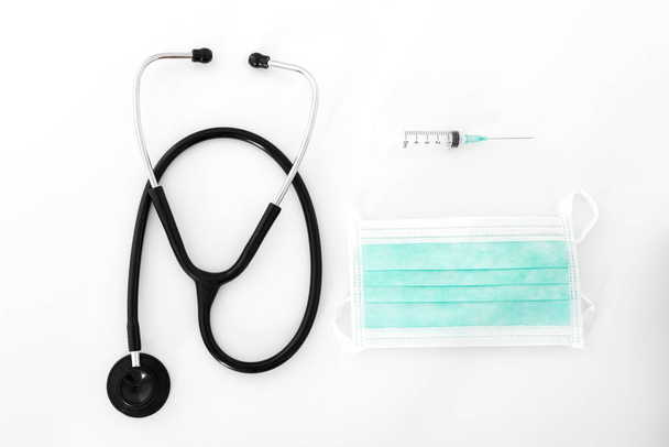 Stethoscope, syringe and mask on white background, closeup - Фото, изображение
