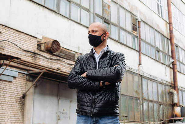 The man wears a black protective mask.The mask prevents corona virus and air pollution by dust. - Fotó, kép
