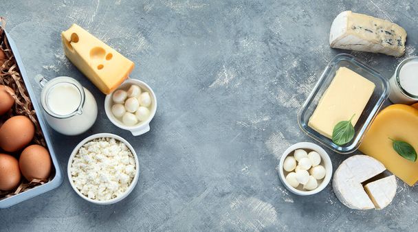 Different types of dairy products on grey background. Top view with copy space - Foto, afbeelding