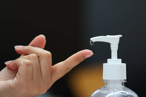 Mãos com garrafa de gel de álcool, enquanto as pessoas caindo em suas mãos para aplicar a proteção contra germes e sujo no fundo branquear no conceito de cuidados de saúde
. - Foto, Imagem