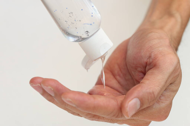 Hands with alcohol gel bottle while people dropping in to their hands for apply protection themselves from germ and dirty on whiten background in Healthcare concept. - Photo, Image