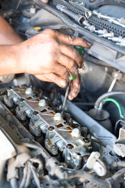 Man hand with screwdriver checking car engine - Photo, Image