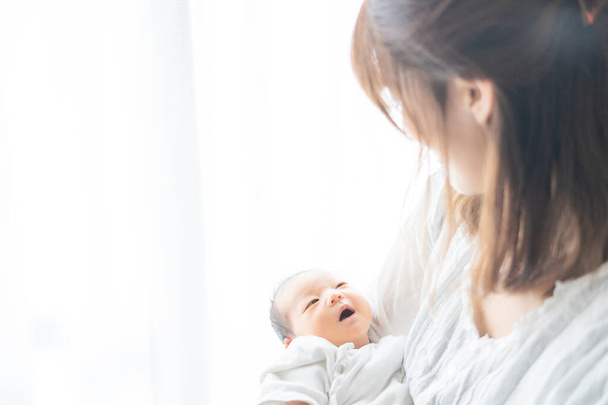 Ázsiai (japán) újszülöttet hordozó anya (0 éves 0 hónapos)) - Fotó, kép