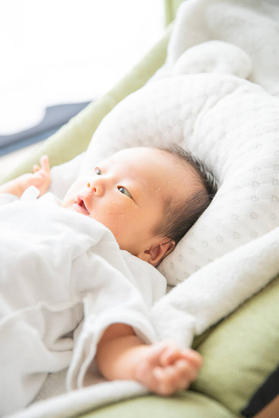 Újszülött ázsiai (japán) baba az ágyban (0 éves 0 hónapos) - Fotó, kép