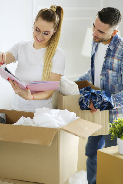 A just married couple unpacking boxes and moving into a new home. Positive emotion. - Foto, Imagem