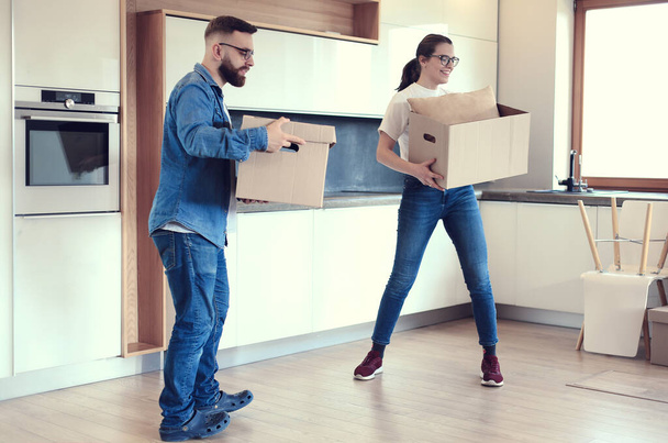 Couple holding boxes for moving the hands and looking inside box - Foto, Imagen