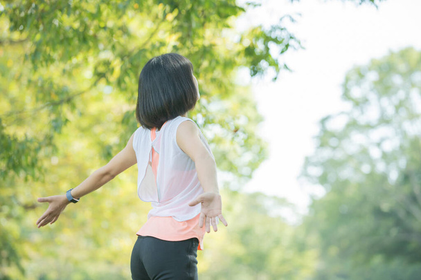 Donna asiatica che prende un respiro profondo durante l'esercizio nel parco
 - Foto, immagini