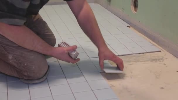 arbeider op een bouwplaats lagen tegels op de vloer - Video