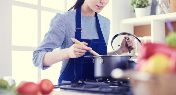 Cooking woman in kitchen with wooden spoon - Fotoğraf, Görsel