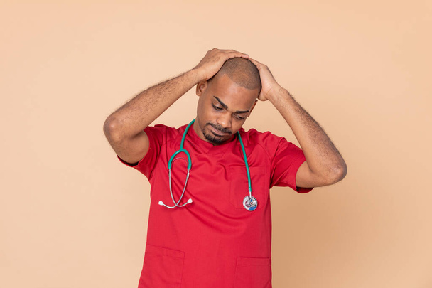Huolestunut lääkäri, jolla on punainen univormu keltaisella pohjalla
 - Valokuva, kuva