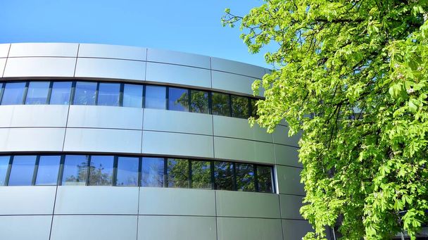 Glazen gebouw met blauwe lucht achtergrond. Modern kantoorgebouw detail, glas oppervlak wolken weerspiegeld in ramen van moderne kantoorgebouw. - Foto, afbeelding