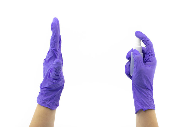 Petit désinfectant vaporisateur dans les mains des médecins avec des gants en caoutchouc sur fond blanc
 - Photo, image