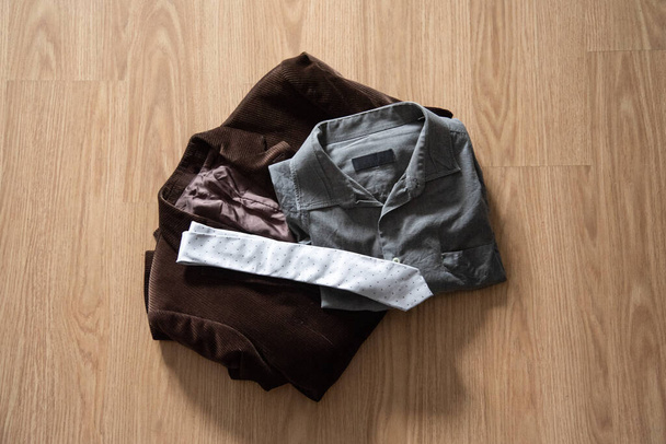 Chaqueta de pana vintage, camisa gris y corbata gris en fondo de madera, imagen horizontal
. - Foto, Imagen