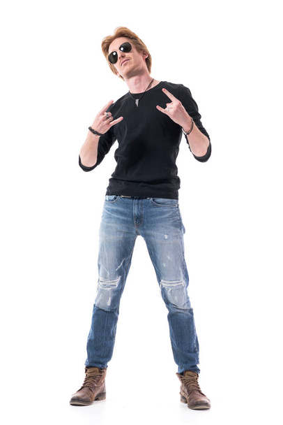 Jonge roodharige knappe rocker met harde rock handen teken gebaar op camera. Volledig lichaam geïsoleerd op witte achtergrond.  - Foto, afbeelding