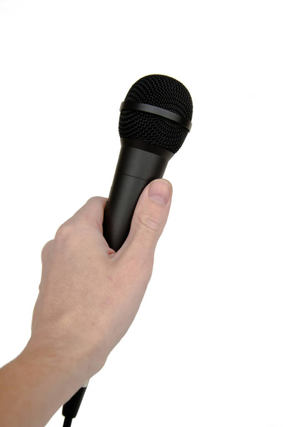 Microphone in hand Isolated on a white background. Microphone in a male hand. - 写真・画像