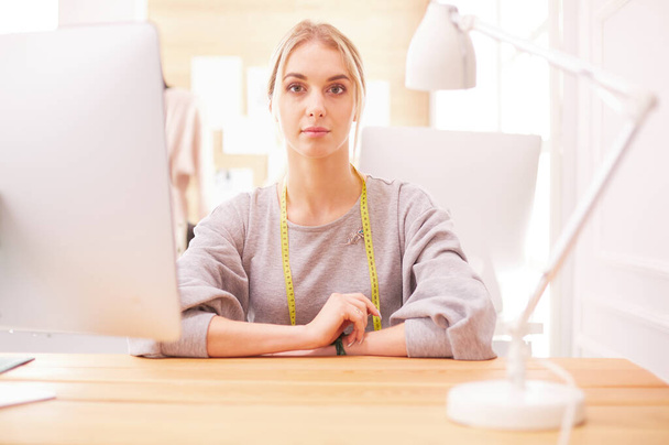 Fashion designer woman working in studio, sitting at thhe desk - Photo, Image