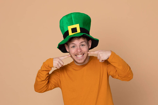 Jovem atraente com um grande chapéu verde em um fundo amarelo
 - Foto, Imagem