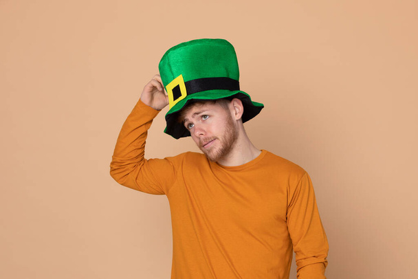 Atractivo joven con un gran sombrero verde sobre un fondo amarillo
 - Foto, imagen