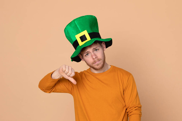 Attraente giovane ragazzo con un grande cappello verde su uno sfondo giallo
 - Foto, immagini