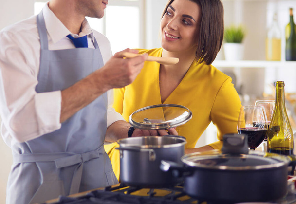 Couple cooking together in the kitchen at home - Фото, зображення