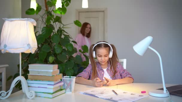 schoolgirl in headphones listening music - Materiał filmowy, wideo