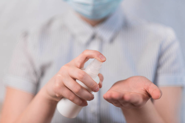 Close-up handen tienerkind, antiseptische spray bescherming bacteriën, hand wassen en desinfectie, anti-coronavirus COVID-19 pandemische infectieziekte uitbraak bescherming, gezondheidszorg concept - Foto, afbeelding