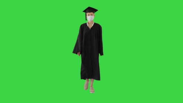 Női diploma a kapitány és a ruha viselése orvosi maszk séta a zöld képernyőn, Chroma Key. - Felvétel, videó